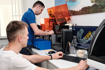 Two dental technicians working in a dental laboratory. 3D modeling of the crown in the dental lab.