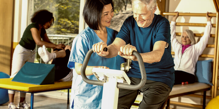 Nurse Assisting Elder People In A Rehab Facility Gym