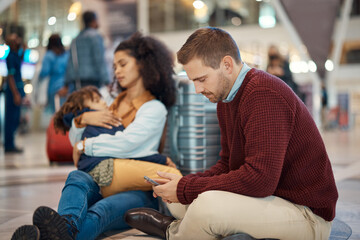 Phone, tired and interracial family waiting at the airport for a delayed flight. Contact, late and...