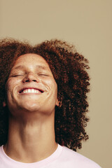 The joy of self-love: Young man with freckles and ginger hair smiles in a studio
