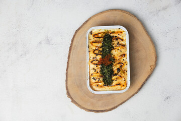 high angle of salmon mentai rice on aluminium foil served on sliced wood with abstract background