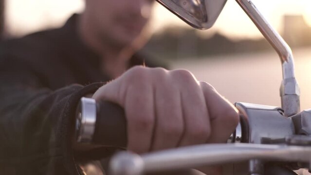 puts his hand on the gas of the motorcycle