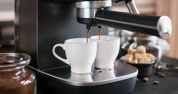 Home Espresso making process - coffee stream pouring from machine into ceramic cup