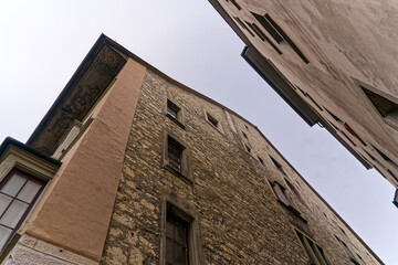 Fototapeta na wymiar Stone facade of historic house at alley of the old town of Swiss City of Schaffhausen on a foggy winter day. Photo taken February 16th, 2023, Schaffhausen, Switzerland.