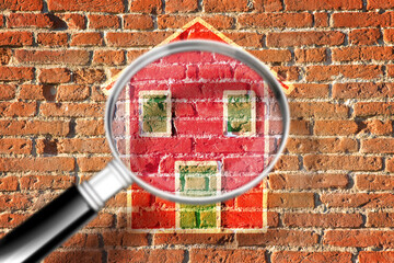 Finding the right home for you! - Concept image with home against a brick wall seen through a magnifying glass