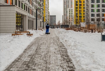 The janitor cleaned the sidewalk from snow