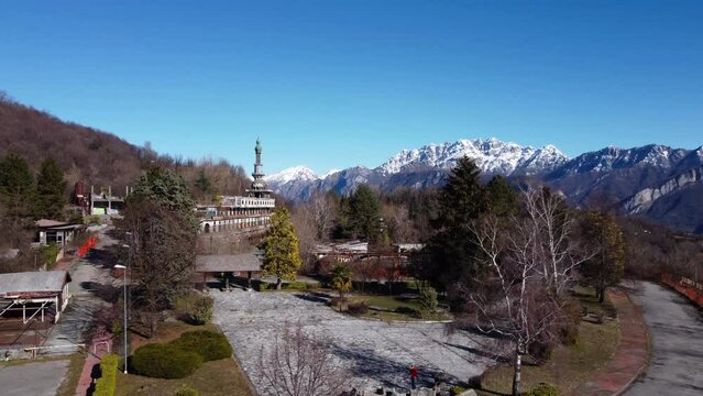 Aerial View Over Consonno Ghost Town In The Olginate Municipality Of The Province of Lecco With Snow Capped Mountains In The Background. Ascending Dolly Back Shot