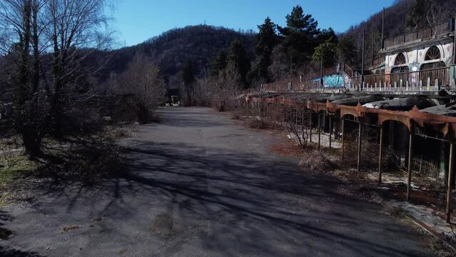 Aerial View Of Empty Abandoned Ground Area Outside The Minaret At Abandoned Ghost Town Consonno. Slow Descending Shot