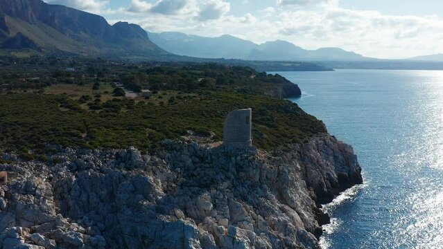 Watchtower Ruins Overlooking Mediterranean Sea In Terrasini, Sicily, Italy. aerial orbit