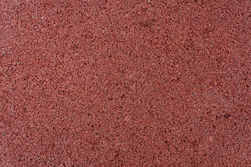Close up of red rubber floor background. rubber flooring for sports and playgrounds, Running racetrack, tennis court.