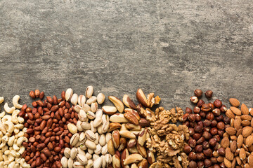 different nuts frame background. Close up, top view, flat lay with vopy space. Walnut, pistachios,...