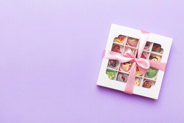 Box with sweet chocolate candies on color background, Various candy sweets. Valentines day gift box. Top view flat lay with copy space
