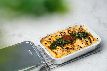 Tasty salmon mentai rice and wooden spoon on abstrack background with green leaves foreground