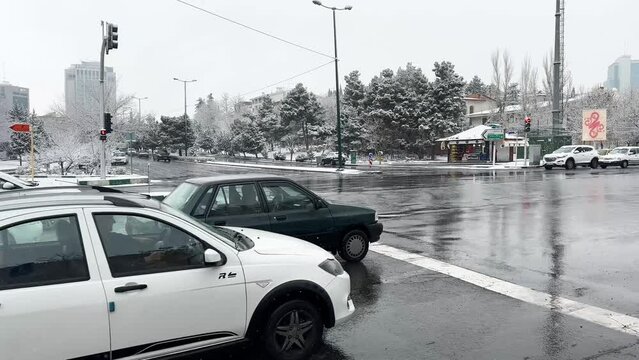 Cross the road junction street light city transportation and pedestrian walking in walkway side walk concept and cars driving fast in winter iced road heavy snowfall in Tehran Iran Snow weather cold