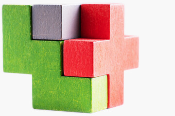 Colorful wooden cube puzzle on the white table. Geometric shapes in different colors. Logical tasks.