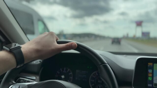 Driver hand on wheel on the interstate. Driving in USA.