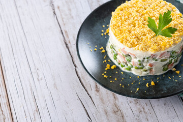 Russian salad or Olivier salad for Christmas dinner on white  wooden table. Copy space