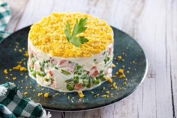 Russian salad or Olivier salad for Christmas dinner on white  wooden table