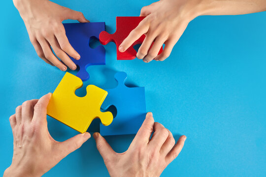 Father and autistic son hands holding jigsaw puzzle shape. World Autism Awareness Day
