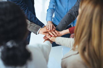 Close up view of young business people putting their hands together. Stack of hands. Unity and teamwork concept. Close-up of co-workers stacking their hands together. Diverse business people