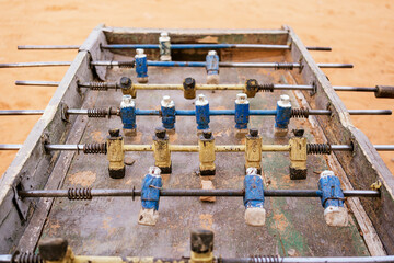 Metal old foosball table with yellow and blue figurines