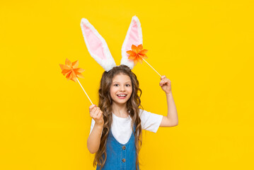 Happy Easter. A little girl is happily celebrating a spring holiday. A child with ears on his head...