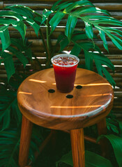 Iced Americano coffee or black coffee in plastic glass on a wooden table in the garden.
