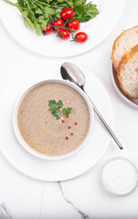 Creamy champignon soup in a white bowl.