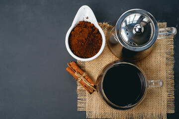 Obraz na płótnie Canvas Black coffee and cinnamon sticks. Aromatic coffee from freshly ground coffee grounds.