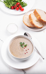 Creamy champignon soup in a white bowl.