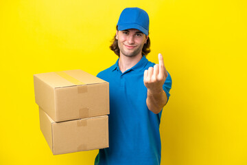Fototapeta na wymiar Delivery handsome man isolated on yellow background doing coming gesture
