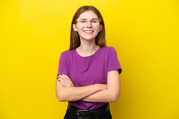 Young English woman isolated on yellow background keeping the arms crossed in frontal position