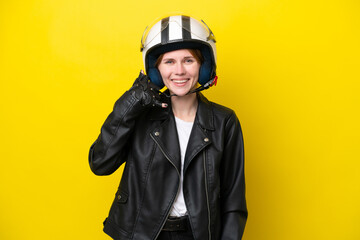 Young English woman with a motorcycle helmet isolated on yellow background making phone gesture. Call me back sign