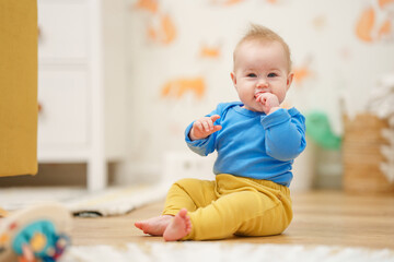 Portrait of charming Caucasian baby toddler with blue eyes in home in children room