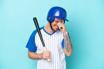 Baseball player with helmet and bat isolated on blue background laughing