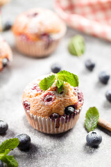 Freshly baked muffins with powdered sugar and fresh berries