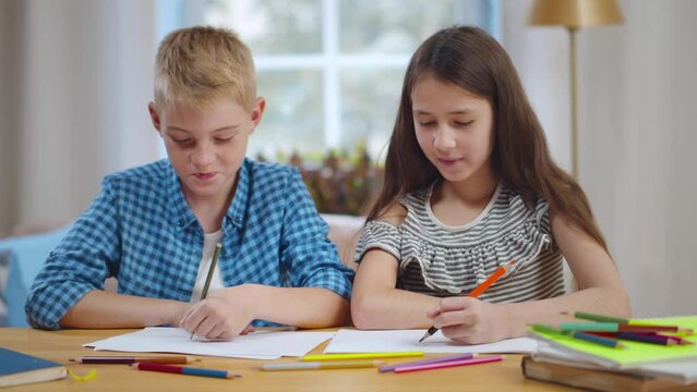 Cute preteen boy and girl studying together at home. Realtime