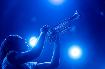 Woman playing the trumpet at a live concert.