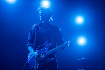 Guitarist performing at a live concert.