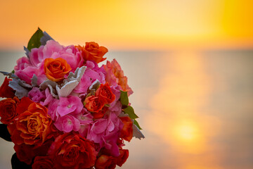 Closeup of bridal bouquet with sunset and ocean in the background