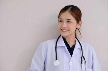 Smiling Asian female doctor Wearing white lab coat and medical stethoscope on shoulders on white background.