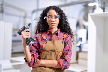 In work place carpenter girl working using pneumatic nail gun stand portrait smiling