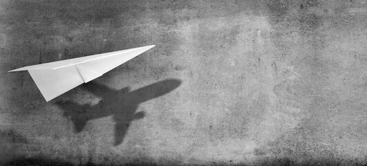 Big idea, startup and motivation concept. Paper plane with shadow on concrete wall background.