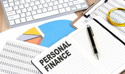 Fototapeta premium PERSONAL FINANCE text on notebook with chart and keyboard
