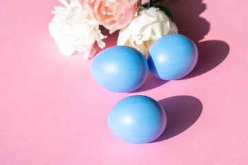 Easter eggs in blue on a pink background with flowers.