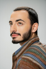 Fototapeta premium portrait of good looking bearded man in colorful shirt looking away isolated on grey.
