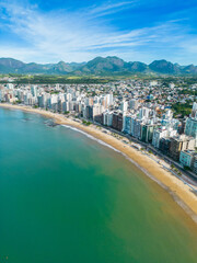 Obraz premium Imagem aérea da Praia do Morro e Praia da Cerca, na região central de Guarapari. Esportes na praia e na água como canoa havaiana e corrida.