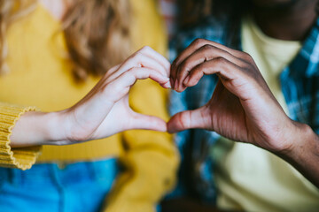 couple caucasian girl and young african american man, friends support each other in difficult times, mental health and support, holding hands in shape of heart, people of different races