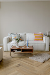 Room with a stylish white sofa and table. Light interior