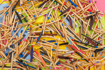 matchsticks of various shapes and colors with multicolored paper sticky notes on background